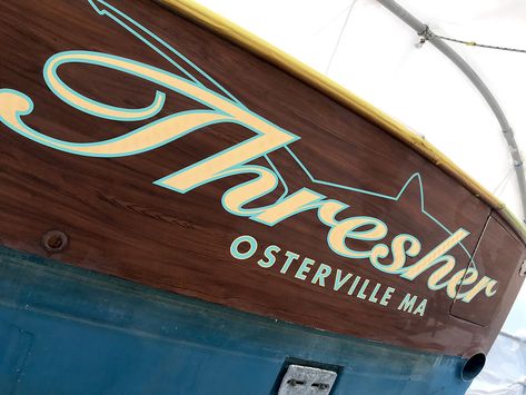 White and black boat on water showing custom boat lettering on hull