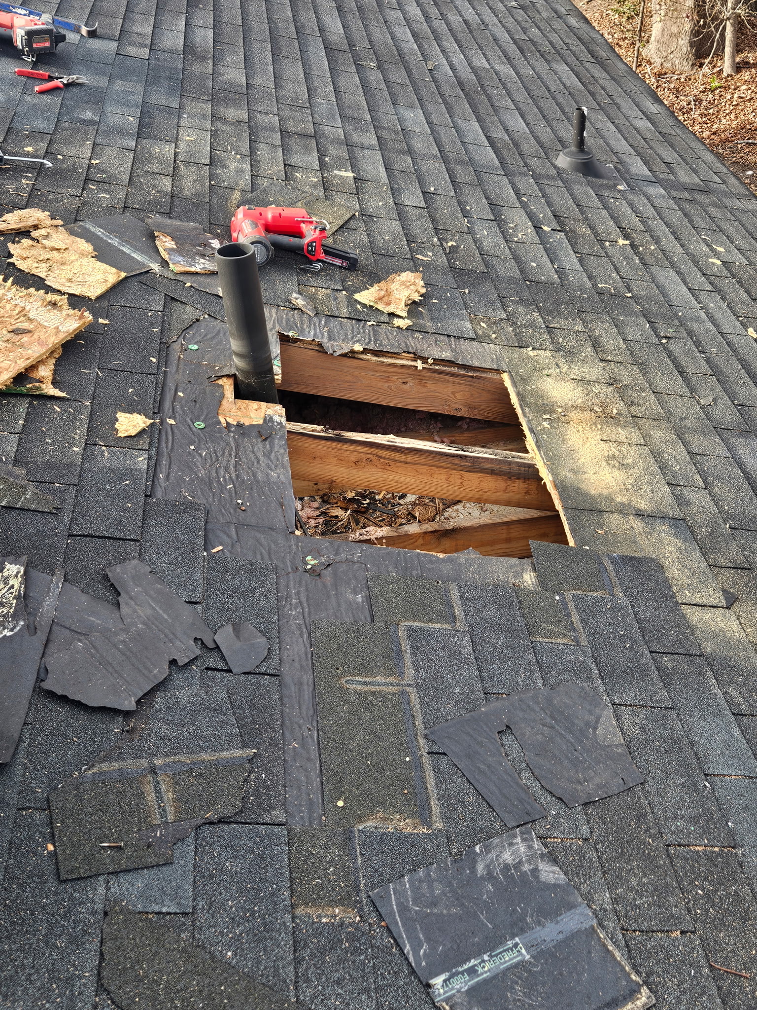 Two BK Roofing contractors performing a targeted shingle repair on a house roof
