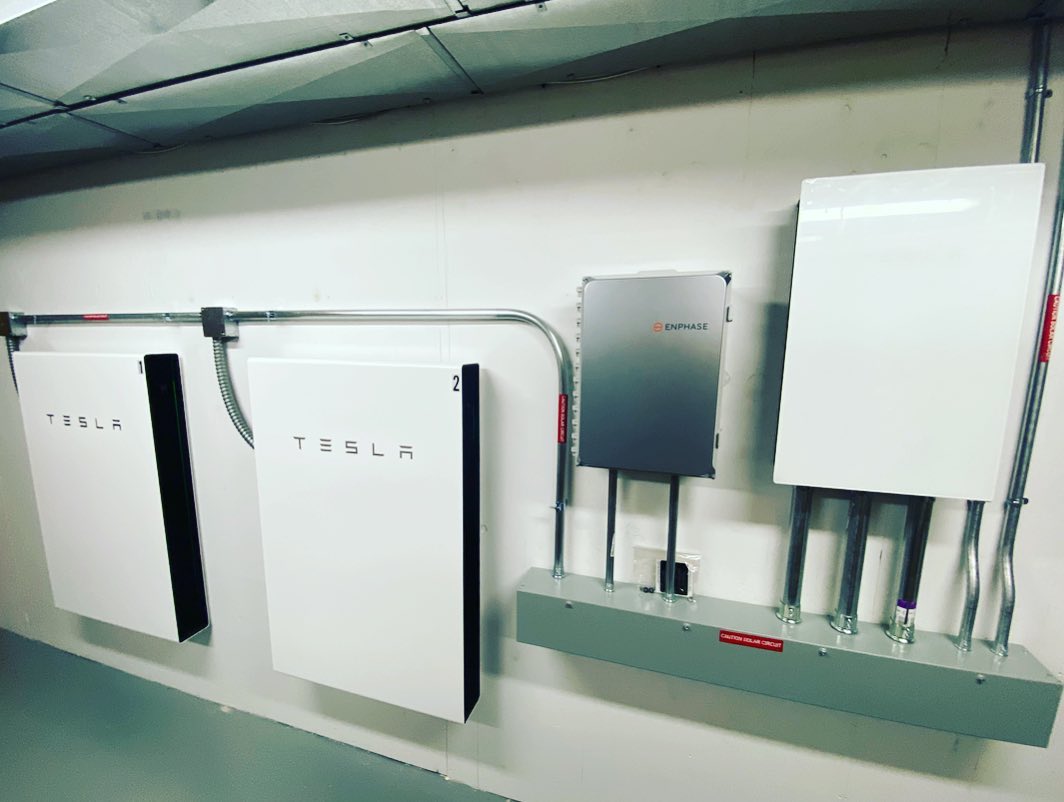 Tesla Powerwall home battery backup unit installed on exterior wall