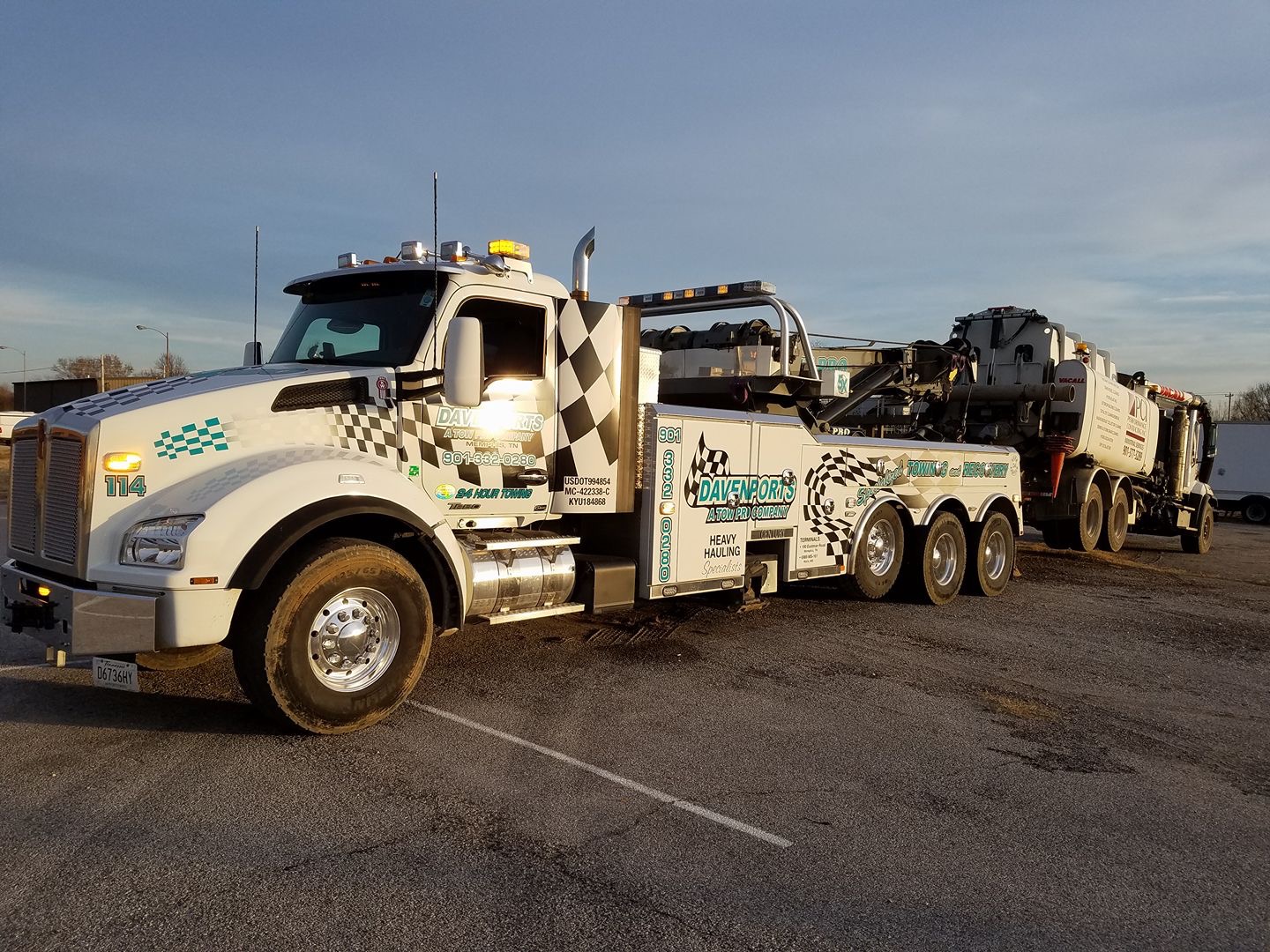 Davenports Towing flatbed tow truck actively loading a vehicle for emergency towing in Memphis