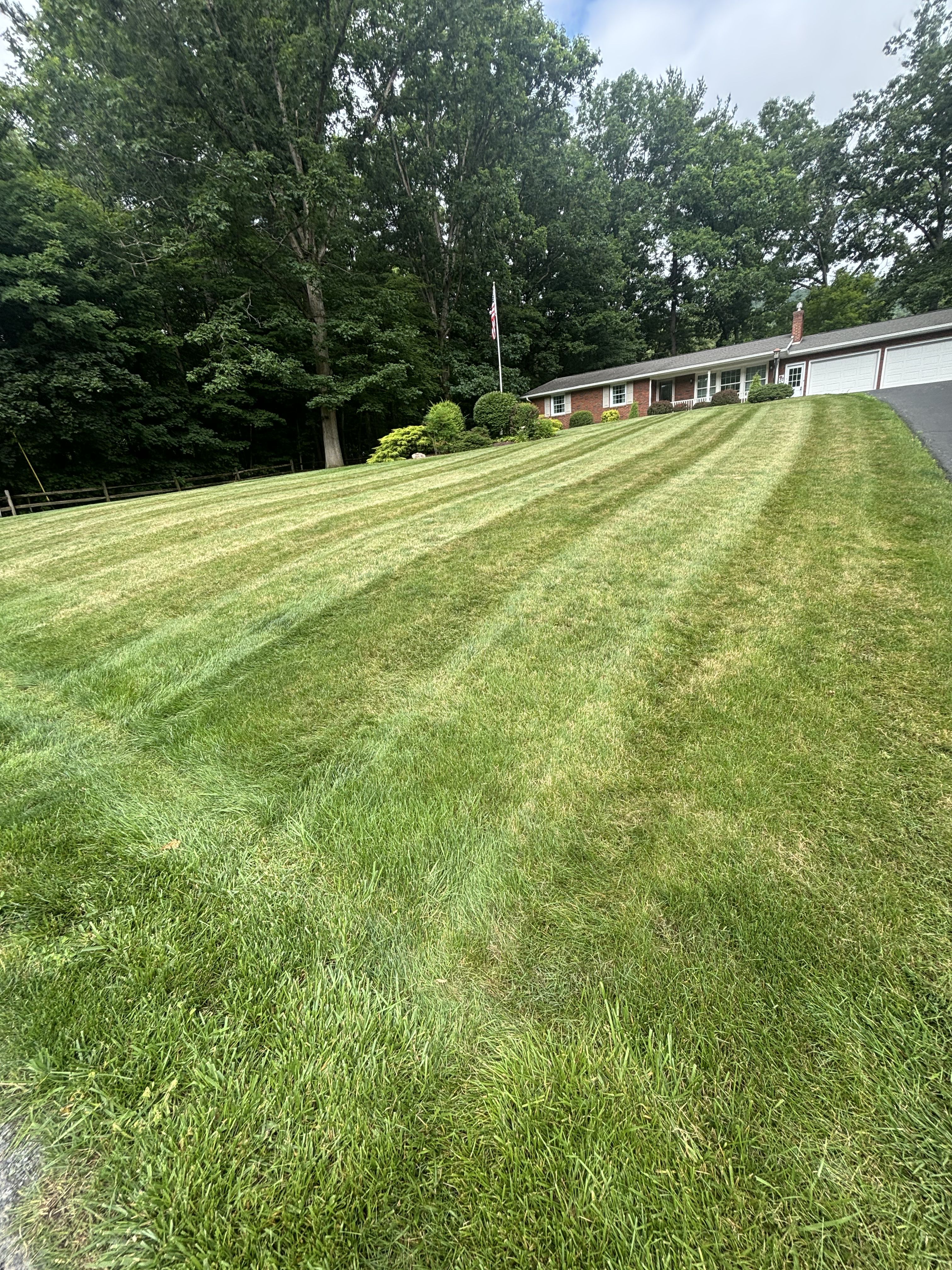 Kimberlings Lawn Care mowing a residential property