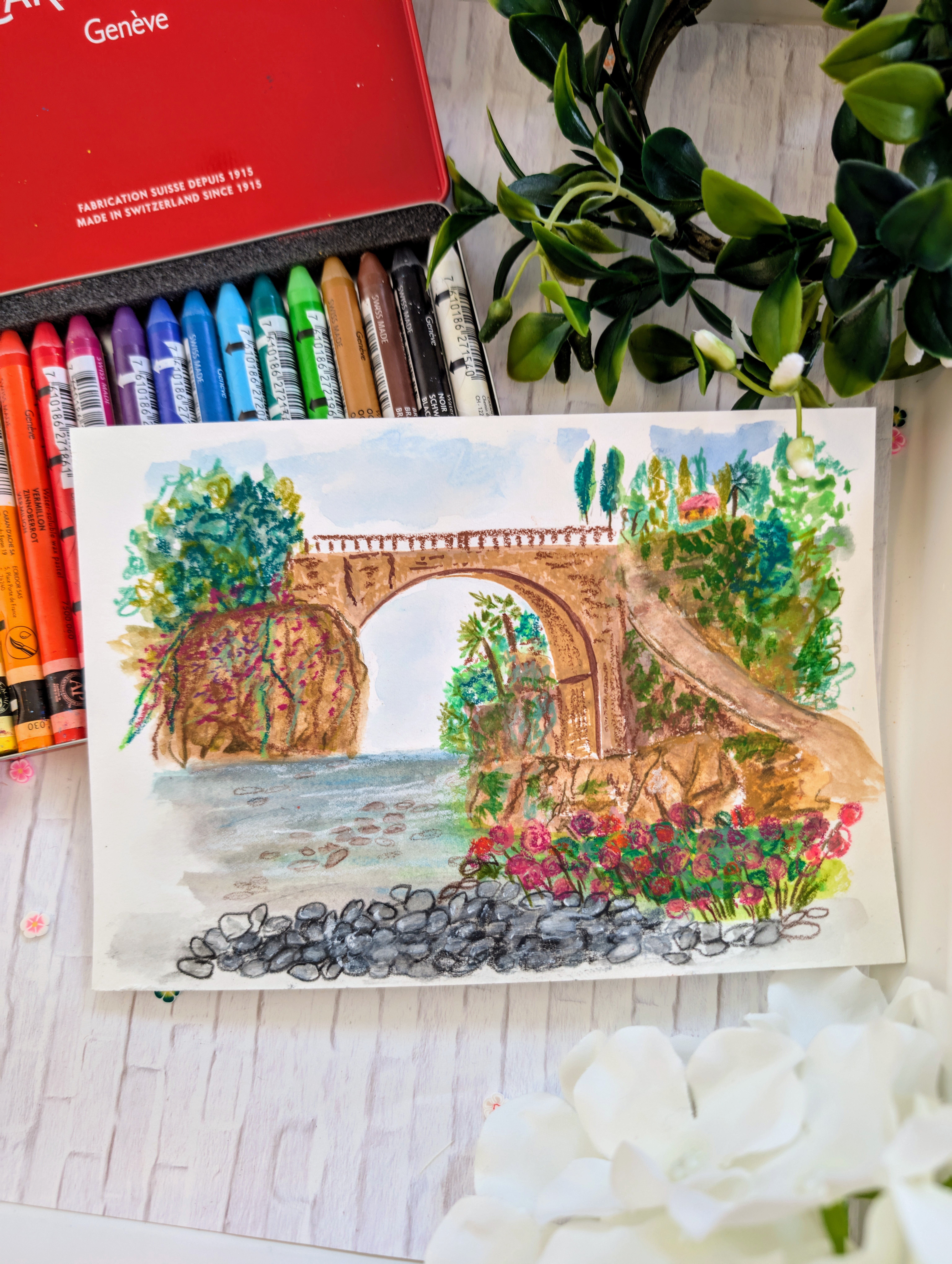 A table topped with lots of handmade craft supplies, paints, and whimsical art pieces