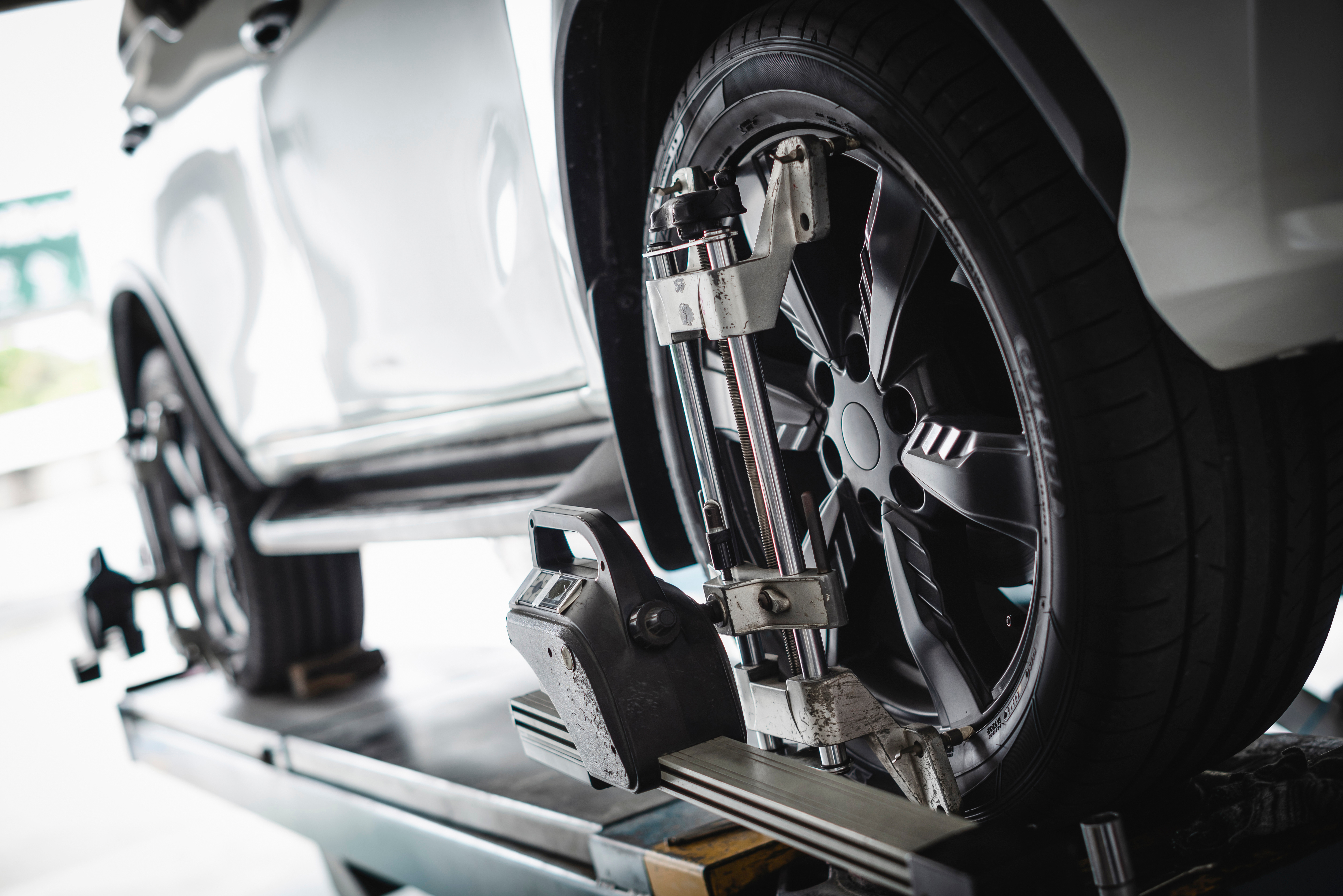 Car in garage undergoing wheel alignment