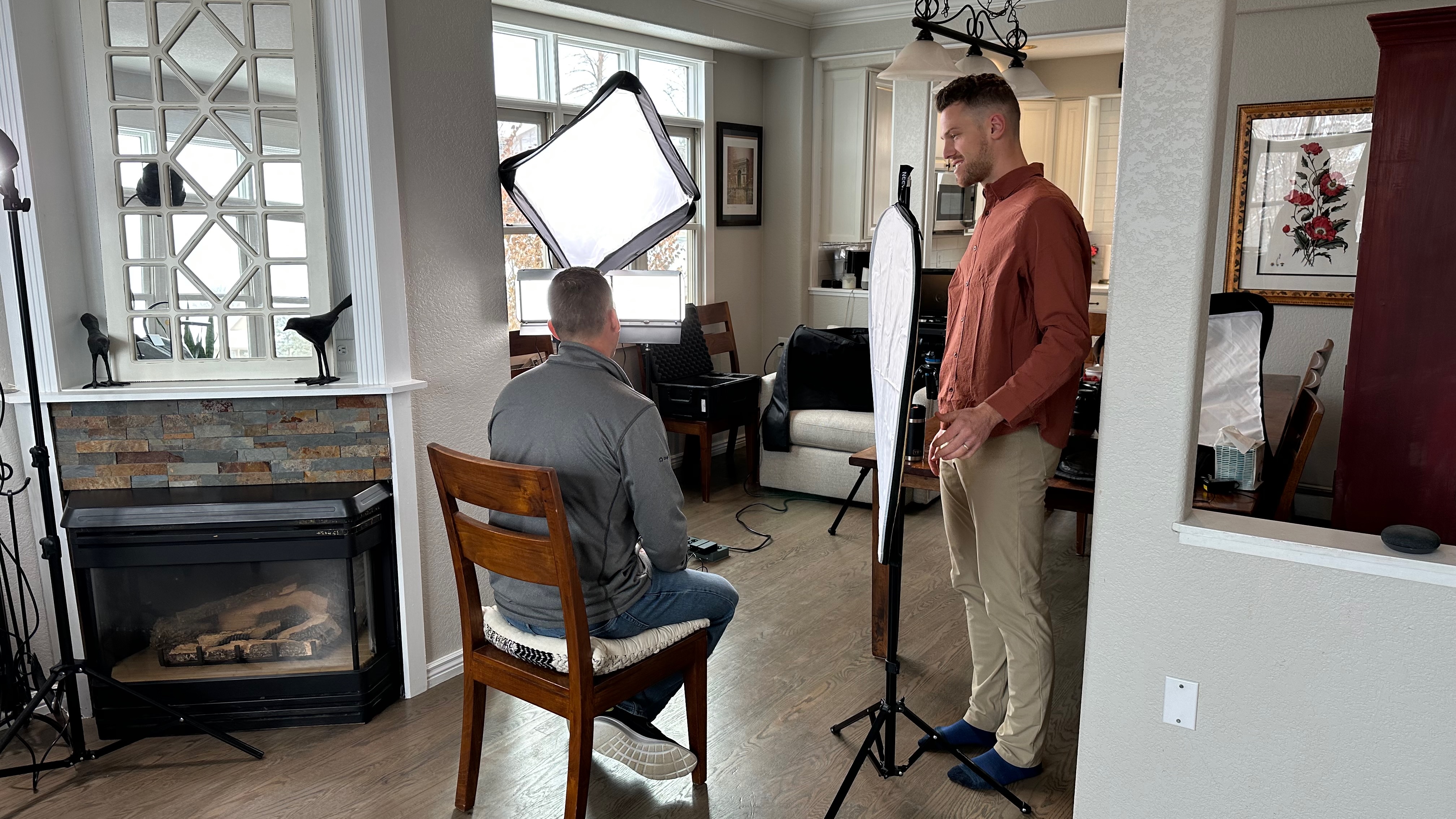 Professional photographer reviewing brand imagery on a laptop in a bright studio