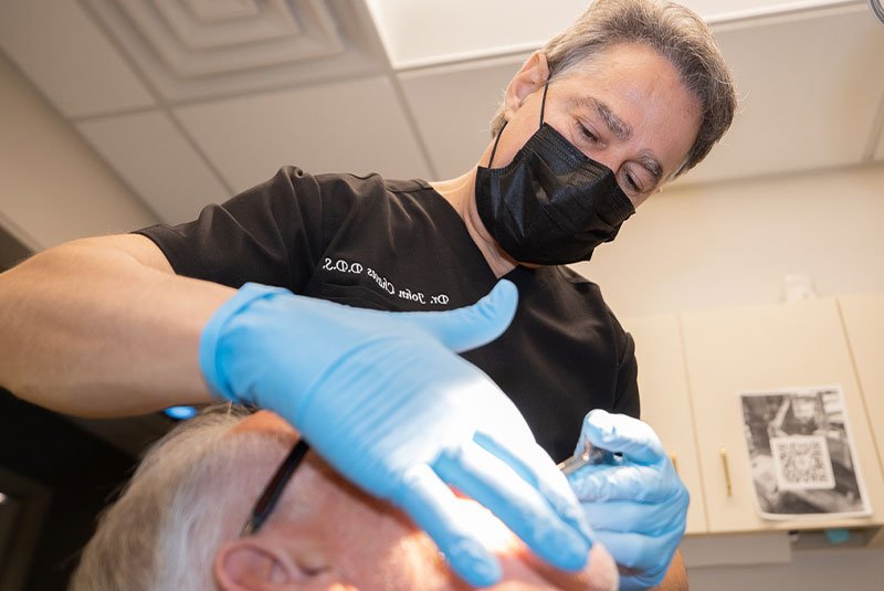 Woman smiling during a dental check-up with a dentist using instruments